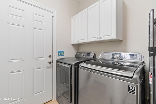 clothes washing area with cabinets and independent washer and dryer