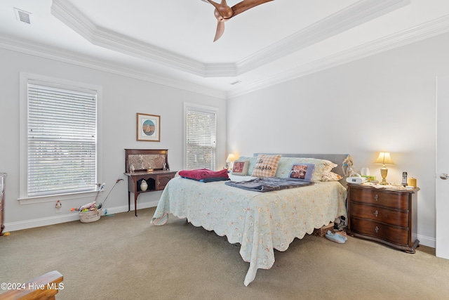 bedroom featuring ceiling fan, light colored carpet, crown molding, and a tray ceiling