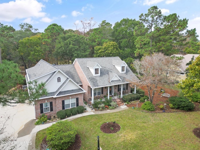 cape cod-style house with covered porch and a front lawn