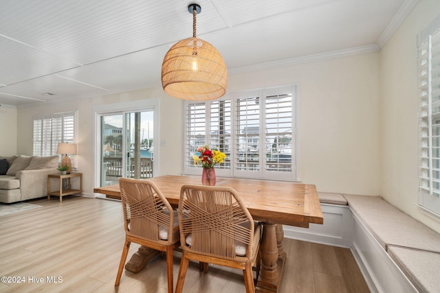 dining room with crown molding and light hardwood / wood-style floors