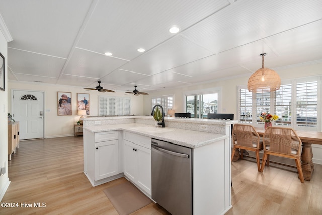 kitchen with pendant lighting, sink, white cabinets, stainless steel dishwasher, and light stone counters