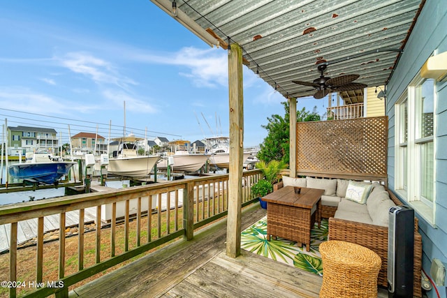 wooden terrace with a boat dock, ceiling fan, and a water view