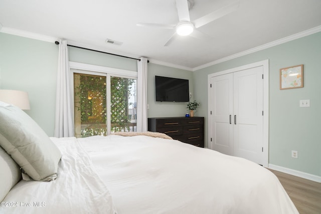 bedroom with ornamental molding, hardwood / wood-style floors, ceiling fan, and a closet