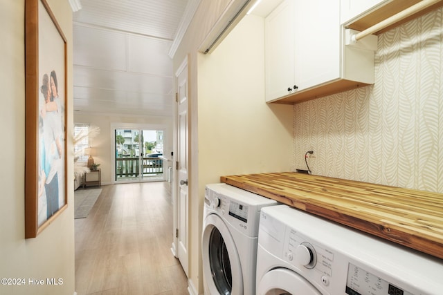 laundry area with crown molding, cabinets, separate washer and dryer, and light hardwood / wood-style floors