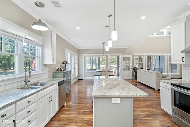 kitchen featuring white cabinets, sink, a kitchen island, and hardwood / wood-style floors