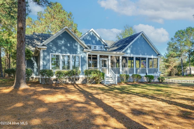 back of property with a sunroom and a yard