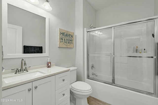 full bathroom with toilet, vanity, bath / shower combo with glass door, and wood-type flooring