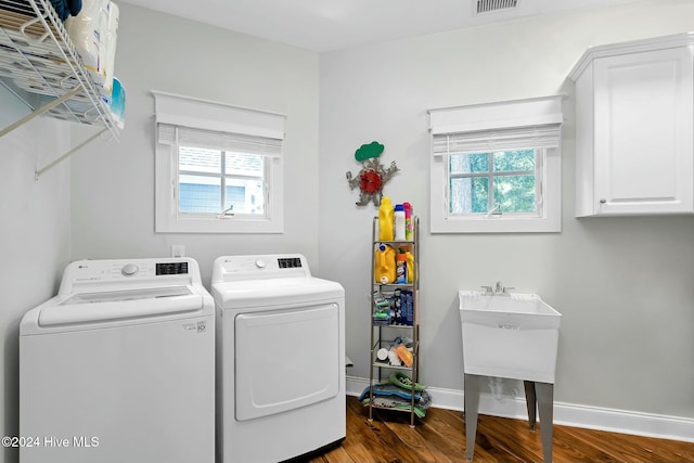 clothes washing area featuring cabinets, dark hardwood / wood-style floors, and independent washer and dryer