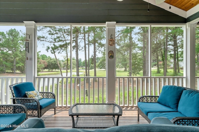 sunroom / solarium featuring a water view, wood ceiling, and vaulted ceiling