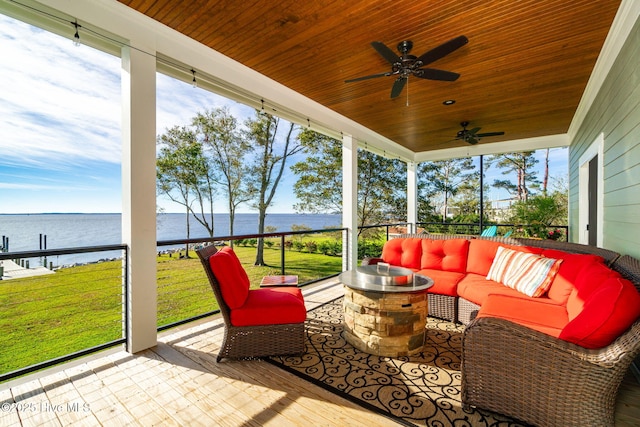 sunroom / solarium with a ceiling fan, a water view, and an outdoor living space