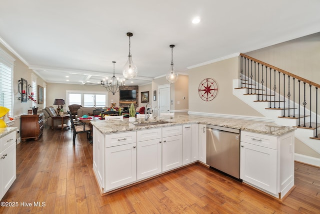 kitchen with crown molding, a sink, light wood-style floors, open floor plan, and stainless steel dishwasher