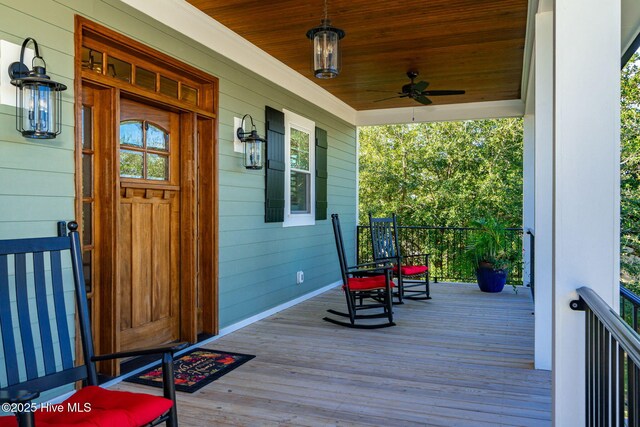 wooden terrace with a ceiling fan and a porch