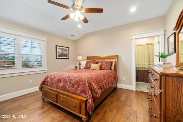 bedroom with baseboards, lofted ceiling, and hardwood / wood-style floors