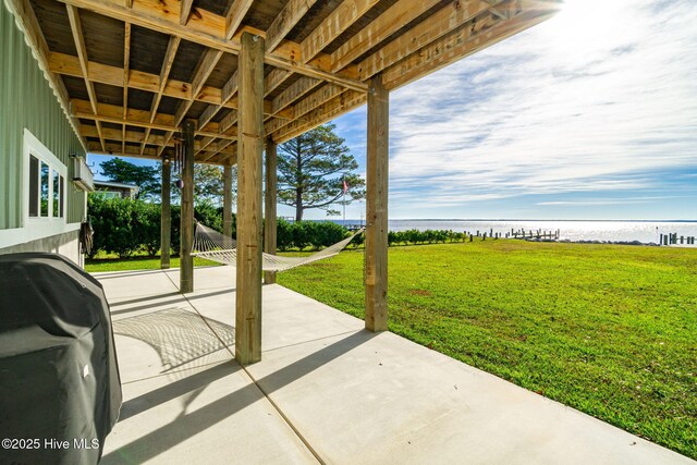 view of patio with grilling area and a water view