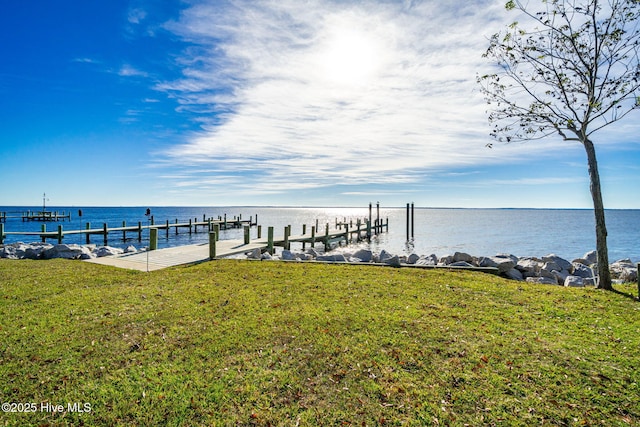 view of dock featuring a water view and a yard