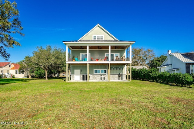 back of property with a lawn, a patio, a ceiling fan, and a balcony