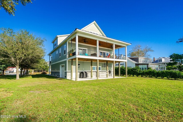 rear view of property with a lawn, a ceiling fan, a patio, and a balcony