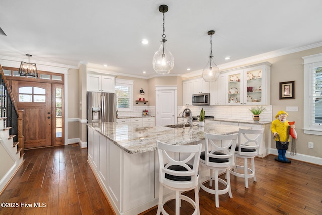 kitchen with a sink, decorative backsplash, white cabinetry, and stainless steel appliances