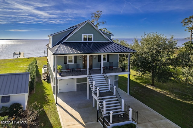 view of front facade featuring covered porch, a water view, a standing seam roof, and stairs