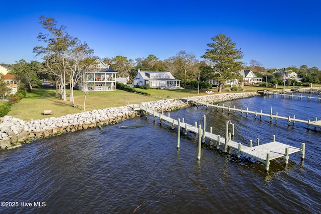 dock area with a lawn and a water view