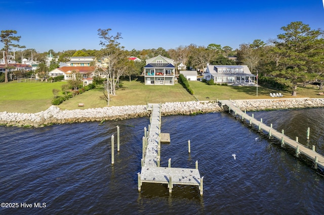 view of dock featuring a lawn and a water view