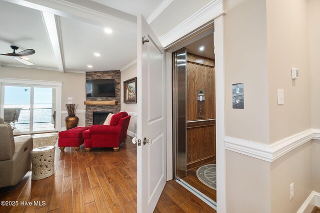 corridor featuring beam ceiling, elevator, ornamental molding, recessed lighting, and hardwood / wood-style floors