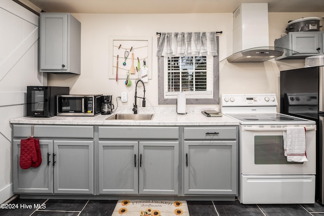 kitchen featuring exhaust hood, sink, white electric stove, gray cabinets, and dark tile patterned floors