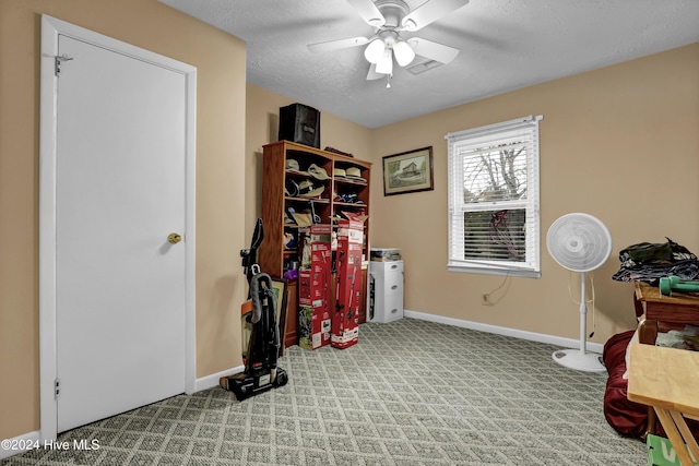 misc room featuring carpet, baseboards, ceiling fan, and a textured ceiling