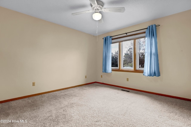 unfurnished room with ceiling fan and carpet