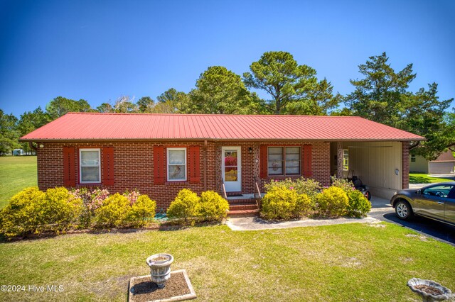 single story home featuring a front lawn and a carport