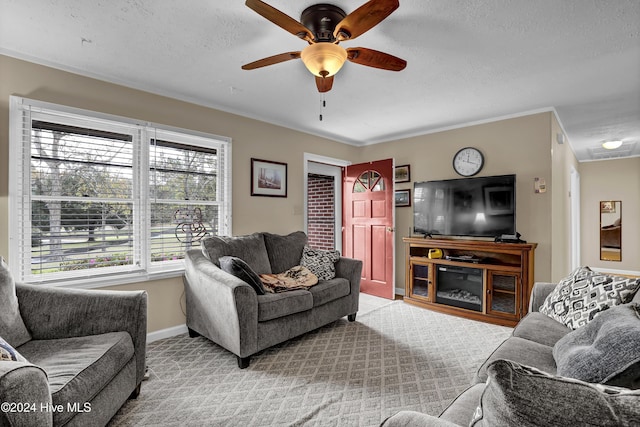 living area featuring light carpet, ceiling fan, baseboards, and a textured ceiling