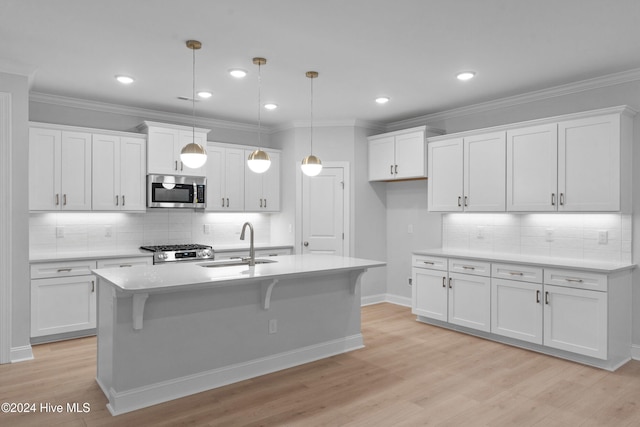 kitchen featuring white cabinetry, hanging light fixtures, stainless steel appliances, and light wood-type flooring