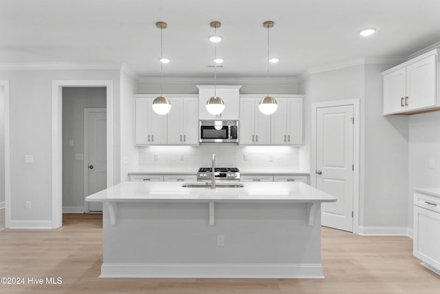 kitchen with stainless steel appliances, decorative light fixtures, light hardwood / wood-style flooring, a center island with sink, and white cabinets