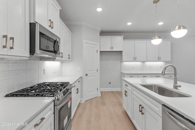 3146 Painted Turtle Loop Unit 12, Wilmington, NC 28409 - kitchen with stainless steel appliances, a sink, white cabinetry, light countertops, and ornamental molding