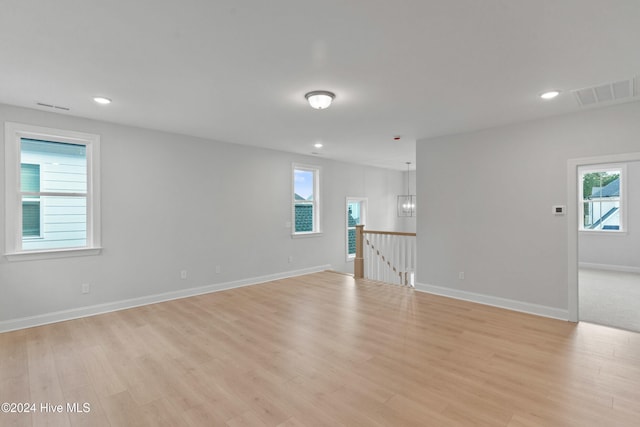 empty room featuring a healthy amount of sunlight and light hardwood / wood-style floors