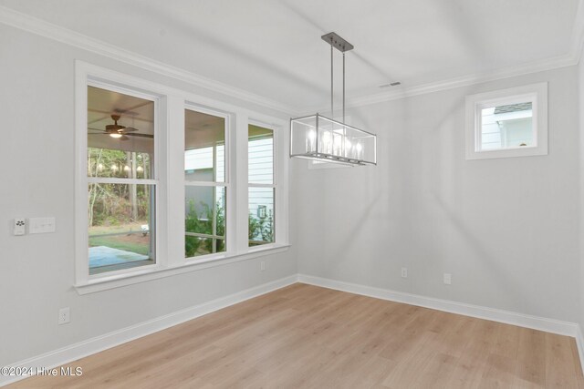 unfurnished dining area with crown molding, plenty of natural light, ceiling fan with notable chandelier, and light hardwood / wood-style flooring