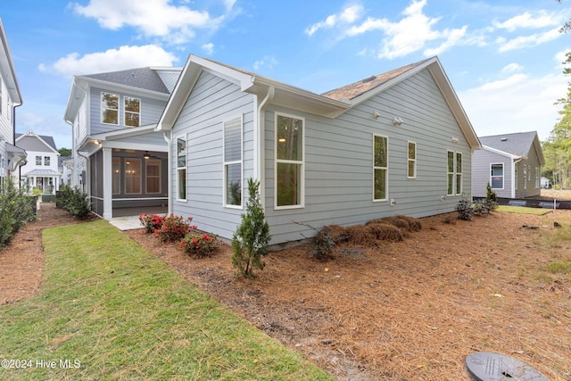 view of side of home with a yard and a sunroom