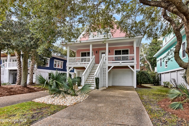 coastal home featuring covered porch and a garage