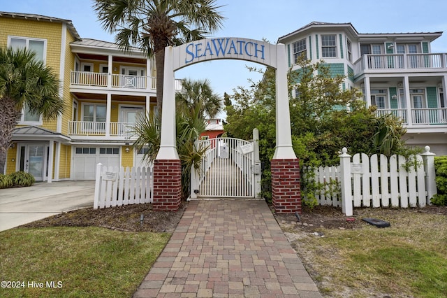 221 Seawatch Way, Kure Beach, NC 28449 - view of front of home featuring a garage, driveway, a gate, and a standing seam roof