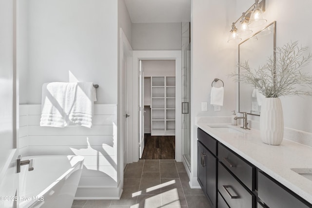 513 Moss Lake Ln, Holly Ridge, NC 28445 - bathroom featuring double vanity, a walk in closet, a freestanding bath, tile patterned flooring, and a sink