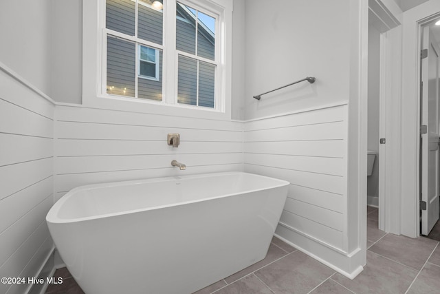 513 Moss Lake Ln, Holly Ridge, NC 28445 - full bathroom with a freestanding tub, wood walls, and tile patterned flooring