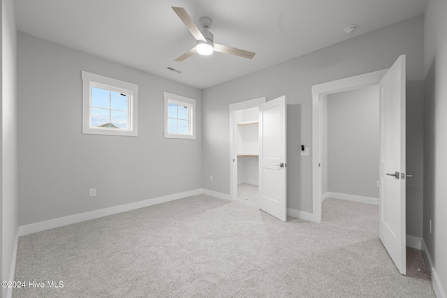 513 Moss Lake Ln, Holly Ridge, NC 28445 - unfurnished bedroom featuring a walk in closet, ceiling fan, visible vents, light colored carpet, and baseboards