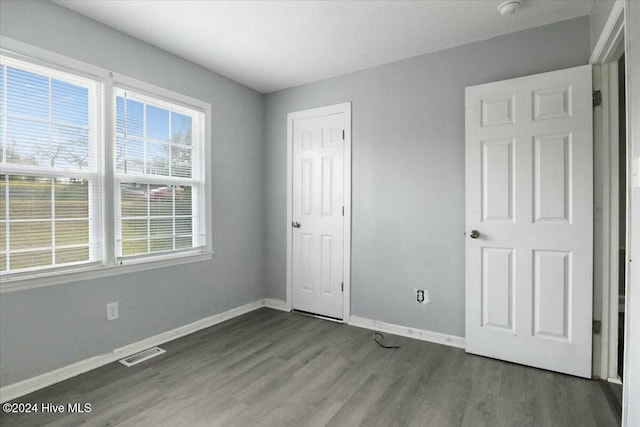 unfurnished bedroom with dark wood-type flooring