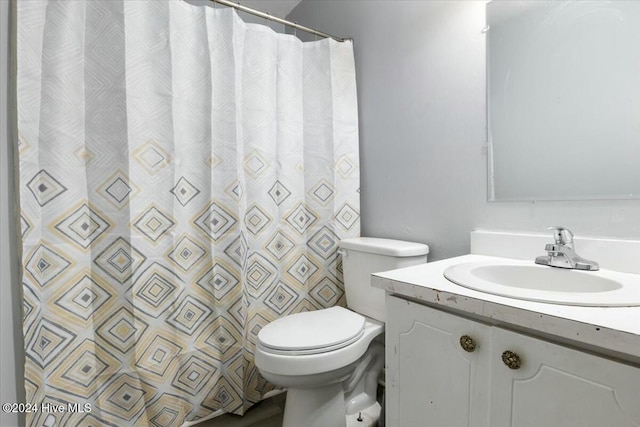 bathroom featuring a shower with curtain, vanity, and toilet