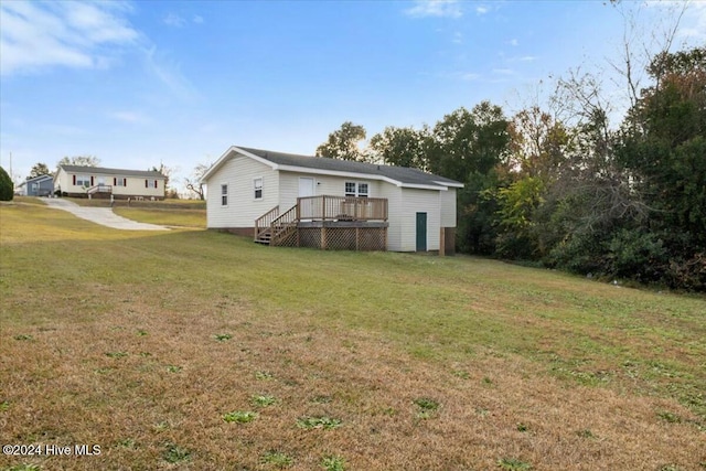 rear view of property featuring a yard and a deck