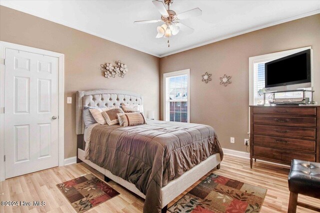 bedroom featuring ceiling fan, ornamental molding, and light hardwood / wood-style flooring