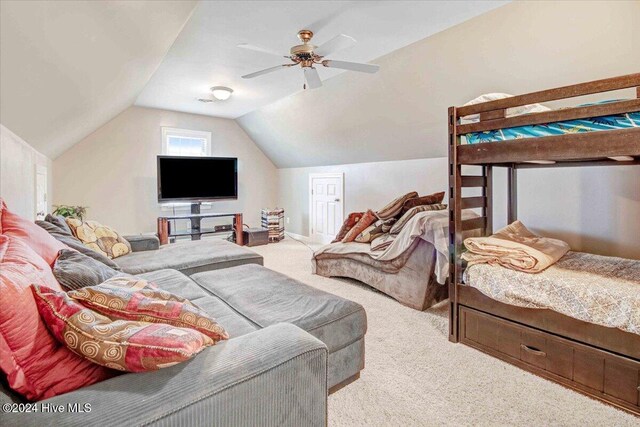 bedroom with ceiling fan, carpet floors, and lofted ceiling