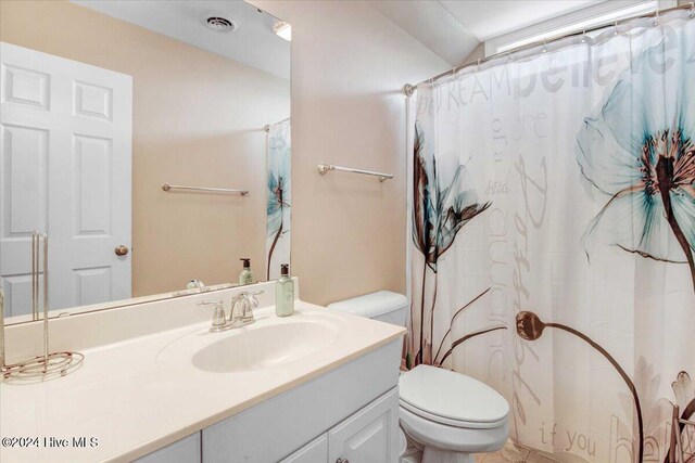 bathroom with vanity, curtained shower, toilet, and lofted ceiling