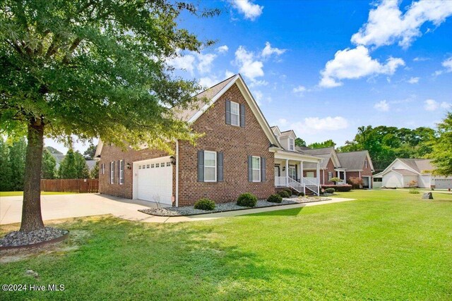 view of front of property featuring a porch, a garage, and a front lawn