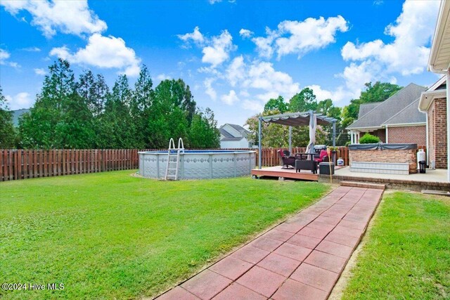 view of yard with a pool side deck and a pergola